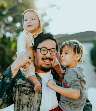 Dad holding children on shoulders and arm